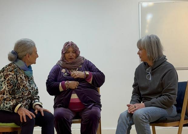 Tres alumnas conversando sentadas en círculo